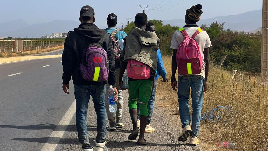 Cinco migrantes caminan por el arcén de la carretera desde la ciudad marroquí de Nador hacia la localidad de Berkán. Según cuentan a EFE, dos de ellos habían estado en el monte Gurugú como paso previo a intentar cruzar a Melilla, pero las redadas de los últimos días les han hecho desistir del intento. EFE/ Mohamed Siali